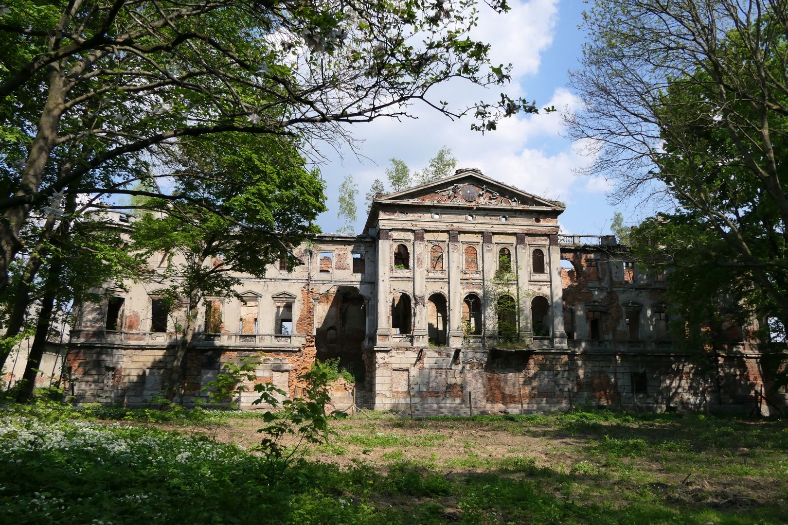 Pałac w Sławikowie widziany od strony parku. Na tympanonie można dostrzec pozostałości zegara słonecznego, zaś na prawo od niego - reszki balustrady. Dach pałacu był płaski i wykorzystywano go jako taras.